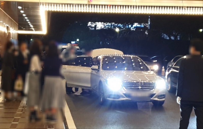 지난해 10월23일 부산 한 호텔에서 조직폭력배 '칠성파'의 전 두목 A씨가 팔순 잔치를 마치고 남성들의 부축을 받으며 차량에 탑승하고 있다.2022.10.23/뉴스1 노경민 기자