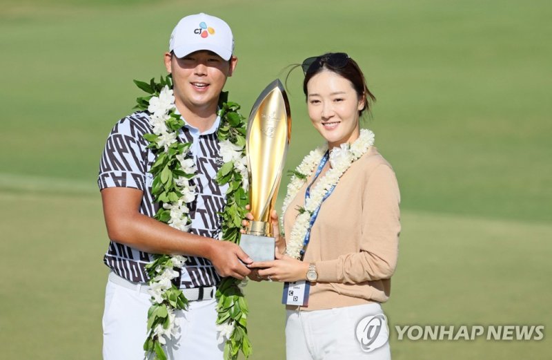 16일(한국시간) 김시우(왼쪽)가 지난해 12월 결혼한 아내 오지현과 함께 우승 트로피를 들고 환하게 웃고 있다. AFP연합뉴스