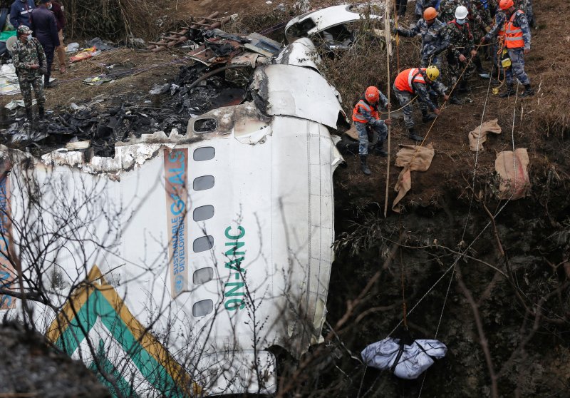 16일(현지시간) 비행기 추락 사고가 발생한 네팔 포카라에서 발견한 시신을 구조대가 끌어올리고 있다. 뉴스1 제공