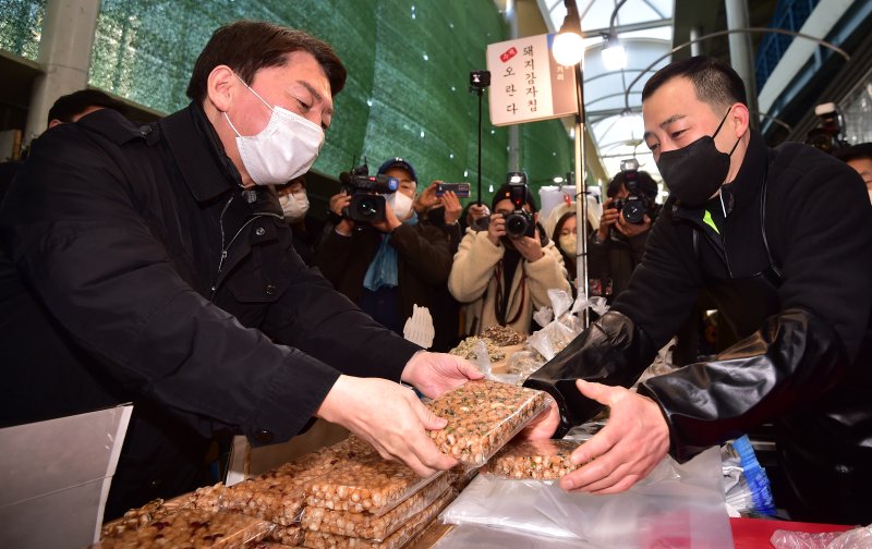 [대구=뉴시스] 이무열 기자 = 국민의힘 당권주자인 안철수 의원이 19일 오후 대구 중구 서문시장을 방문해 과자를 구매하고 있다. 2023.01.19. lmy@newsis.com
