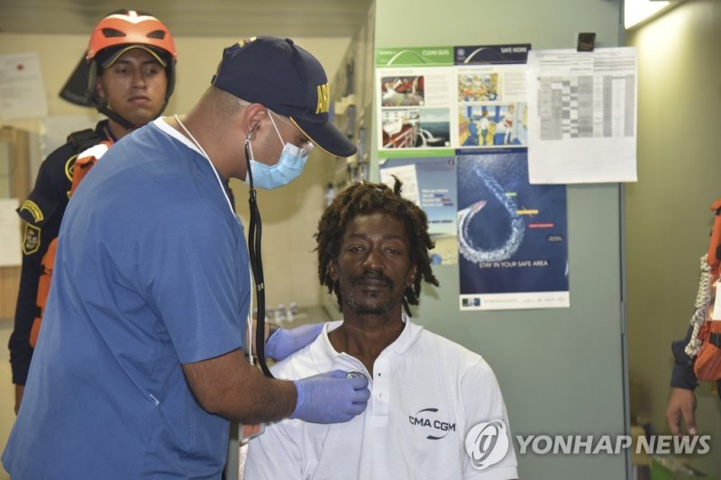 In this photo provided by Colombia's Navy press office, castaway Elvis Francois is attended by Colombian Navy members after he was rescued near the department of La Guajira, in the extreme north of Colombia, as he sits on board the merchant ship CMA CGM Voltario at the port of Cartagena, Colombia, M