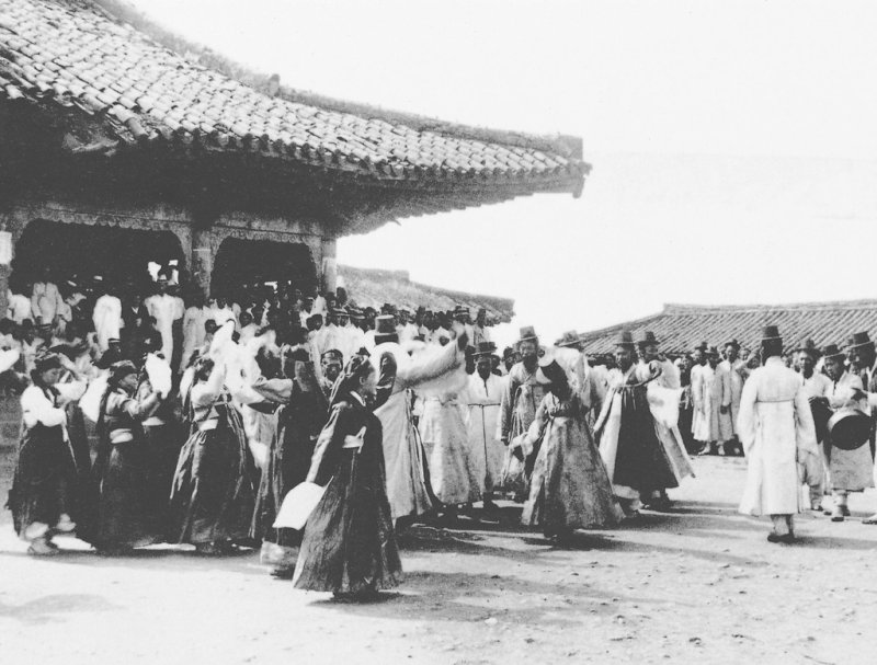 1900년대 제주 입춘굿 (제주=연합뉴스) 1900년대 관덕정을 배경으로 펼쳐졌던 입춘굿놀이에서 춤을 추며 노는 출연자들을 갓을 쓴 유생들이 지켜보고 있다. 제주시가 2000년 발간한 '20세기 제주시' 사진집에서 발췌. [제주시 제공, 재판매 및 DB 금지]