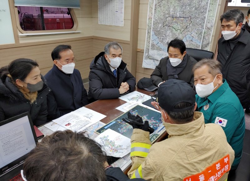 이상민 행정안전부 장관이 설 연휴를 앞둔 지난 20일 오전 서울 강남구 구룡마을 화재 현장을 찾아 소방관계자로부터 상황보고를 받고 있다. 이 장관은 대피주민 난방 등 생활에 불편함이 없도록 필요한 조치를 할 것 당부했다. 행정안전부 제공