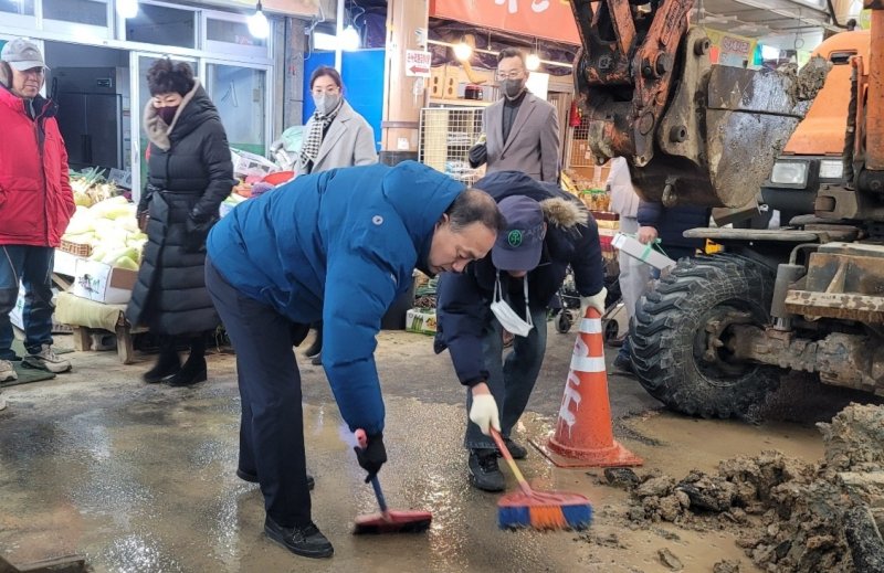 김원이 의원(전남 목포시)이 21일 목포동부시장 상수도 동파현장을 찾아 정리작업을 함께하고 있다.(김원이 의원실 제공)2023.1.21/뉴스1