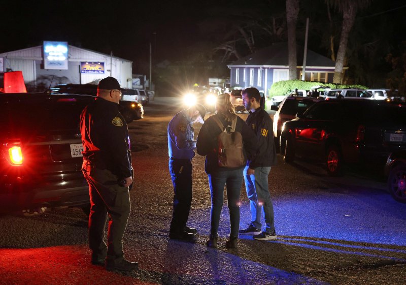미국 연방수사국(FBI) 주민들이 23일(현지시간) 캘리포니아주 해프문베이에서 총격 사건 인근 현장을 통제하고 있다.AFP연합뉴스