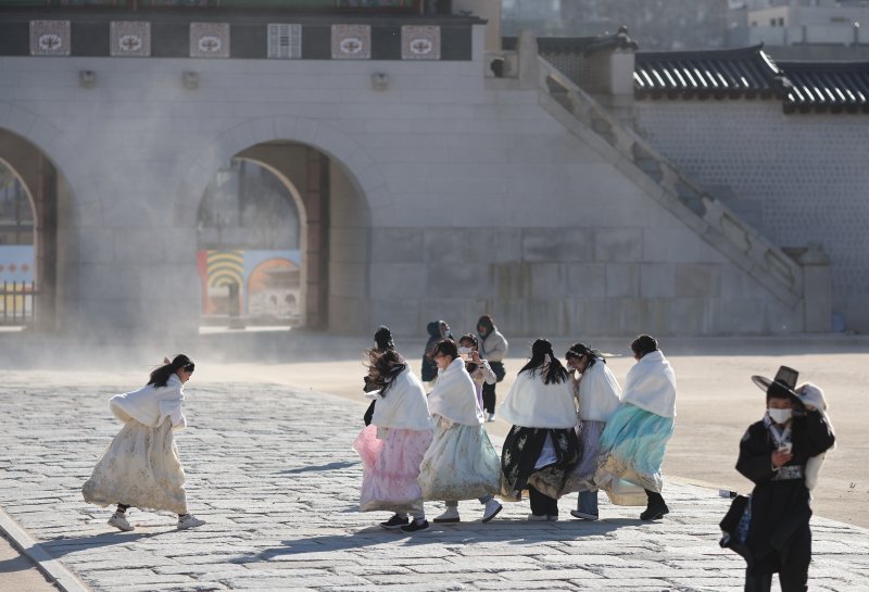 한파특보가 발령된 24일 오후 경복궁을 찾은 관광객들이 바람을 맞으며 걷고 있다. 연합뉴스