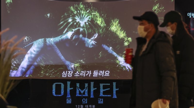 [영화 '아바타2'가 누적 관객 수 천만명을 돌파한 지난 24일 오후 서울 시내의 한 영화관에서 관람객 뒤로 영화 홍보물이 나오고 있다. /뉴시스