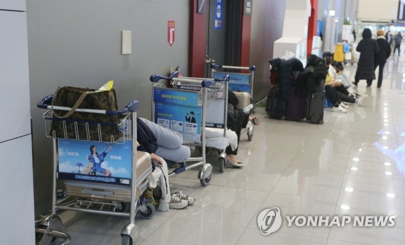 제주공항 손수레에 누운 결항편 승객. 연합뉴스