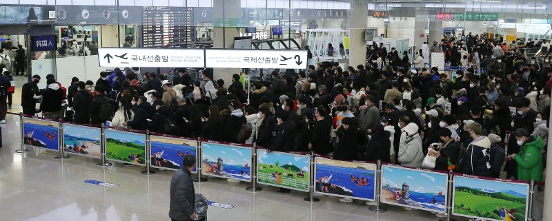 제주공항 운항이 재개된 25일 오전 폭설과 강풍으로 발이 묶인 관광객과 도민들이 한꺼번에 공항에 몰리면서 3층 출발장이 혼잡을 빚고 있다. 연합뉴스