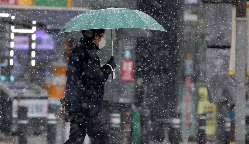 눈이 내리는 지난 15일 서울 동대문구 이문동에서 한 시민이 발걸음을 재촉하고 있다. /뉴스1