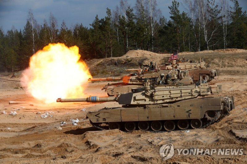 훈련 중인 미국 육군의 A1 에이브럼스 탱크 FILE PHOTO: U.S. Army M1A1 Abrams tank fires during NATO enhanced Forward Presence battle group military exercise Crystal Arrow 2021 in Adazi, Latvia March 26, 2021 REUTERS/Ints Kalnins/File Photo