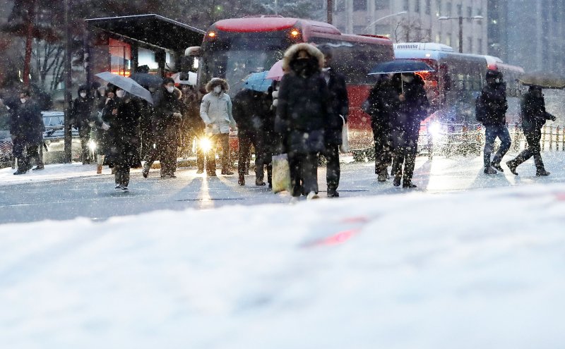눈이 내리고 있는 26일 서울 명동성당 사거리에서 시민들이 출근하고 있다.