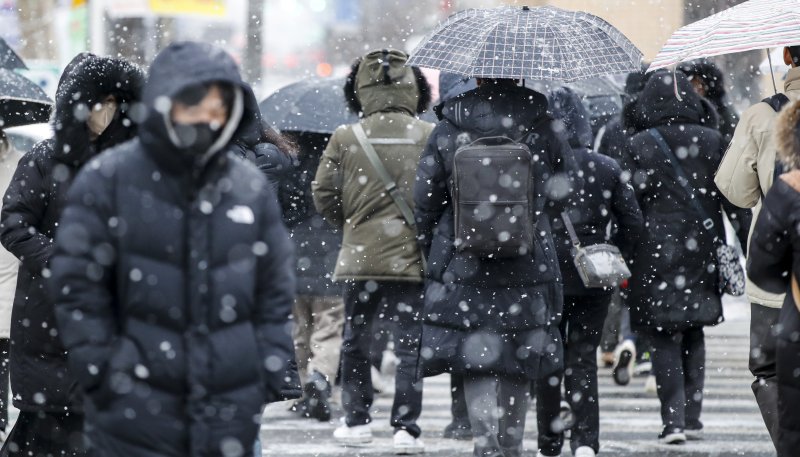 중부지방을 중심으로 많은 눈이 내리고 있는 26일 오전 서울 세종대로사거리에서 시민들이 출근길 발걸음을 재촉하고 있다. 2023.1.26/뉴스1 ⓒ News1 김도우 기자