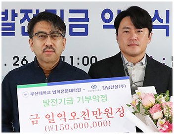 서정규 강남건설㈜ 대표이사(오른쪽)가 발전기금을 전달하며 윤석찬 부산대 법학전문대학원장와 기념촬영을 하고 있다. 부산대학교 제공