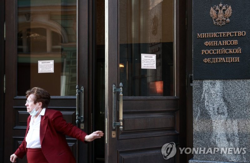 모스크바의 러시아 재무부 청사 MOSCOW, RUSSIA ? FEBRUARY 28, 2022: A woman at the entrance to the Russian Finance Ministry headquarters in Ilinka Street, central Moscow. US Department of the Treasury has banned American citizens from making transactions with the Bank of Russia, the Russian National Wealth Fund, a