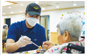 한 사회복무요원이 한 노인의 식사를 정성껏 돕고 있다.