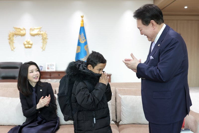 윤석열 대통령과 김건희 여사가 31일 용산 대통령실 청사를 찾은 캄보디아 소년 옥 로타(14)군에게 학용품 이 든 책가방을 선물하고 있다. (대통령실 제공) 2023.1.31/뉴스1 ⓒ News1 오대일 기자