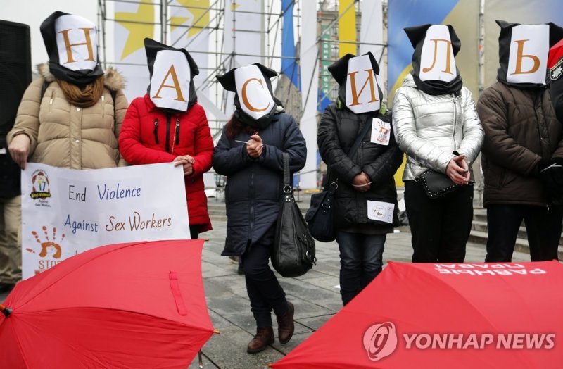 유럽 인기 매춘관광지였던 우크라…전쟁통에 성매매여성 이중고 epa06388929 Ukrainian sex workers and activists who support them stand with bags on their heads, which form the word 'Nasiliye (Violence)' during their performance on the Independence Square in Kiev, Ukraine, 14 December 2017. Protestors gathered to mark 'The Interna