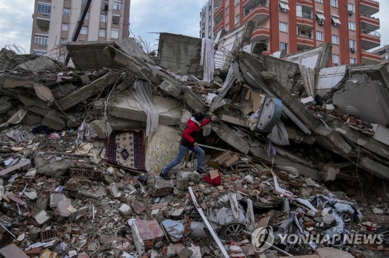 무너진 건물서 생존자 찾는 튀르키예 남성 A man walks among rubble as he searches for people in a destroyed building in Adana, Turkey, Monday, Feb. 6, 2023. A powerful quake has knocked down multiple buildings in southeast Turkey and Syria and many casualties are feared. (AP Photo/Khalil Hamra)