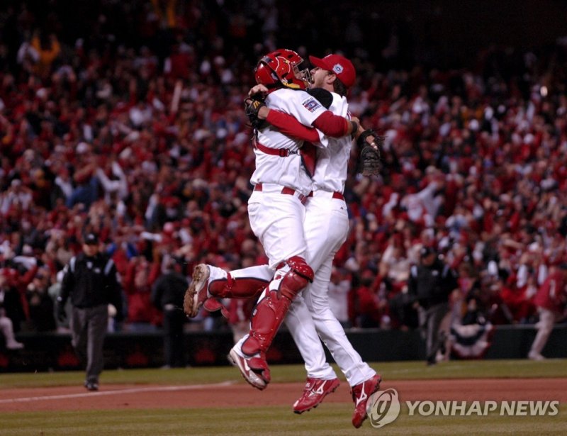 포옹하는 애덤라이트(오른쪽)와 몰리나 epa00850329 St. Louis Cardinals' closing pitcher Adam Wainwright (R) celebrates with catcher Yadier Molina (L) after striking-out Detroit Tigers' Brandon Inge for the final as the Cardinals win Game 5 to take the World Series at Busch Stadium in St. Louis, Missouri Friday, 27 Oc