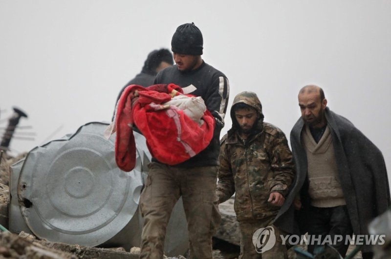 EDITORS NOTE: Graphic content / A Syrian man carries the body of an infant who was killed in an earthquake in the town of Jandaris, in the countryside of Syria's northwestern city of Afrin in the rebel-held part of Aleppo province, on February 6, 2023. - Hundreds have been reportedly killed in north