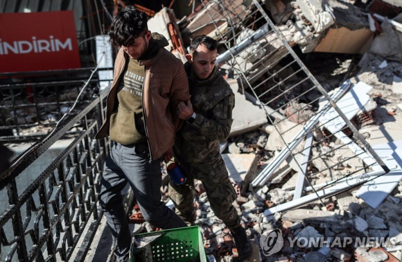 epaselect epa10454913 A Turkish soldier arrests an alleged looter man in front of a collapsed building after an earthquake in Hatay, Turkey, 08 February 2023. More than 11,000 people have died and thousands more are injured after two major earthquakes struck southern Turkey and northern Syria on 06 