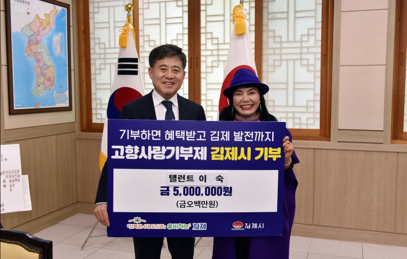 전원일기에서 '쌍봉댁'으로 출연한 배우 이숙씨(사진 오른쪽)가 정성주 김제시장에게 고향사랑기부금 500만원을 기탁하고 있다.(김제시제공) 2023.2.13/뉴스1