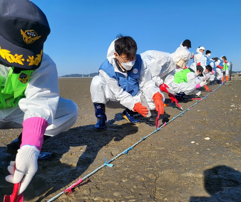 지난해 포스코건설 임직원들이 인천 선재도 갯벌에 토종 염생식물인 칠면초를 파종하는 활동을 하고 있다. 포스코건설 제공