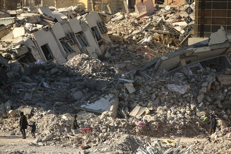 강진으로 건물들이 주저앉은 튀르키예 남부 아디야만에서 13일(현지시간) 주민들이 잔해 더미 주변을 걷고 있다. 841억달러 손실이 발생한 것으로 추정되는 가운데 세계은행(WB)은 복구비용으로 수십억달러가 필요할 것으로 전망했다. AP뉴시스