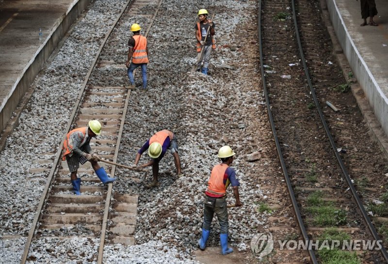 미얀마 철도 epa07645985 Myanmar workers repair rail tracks of the Yangon circular railway upgrade project in Yangon, Myanmar, 13 June 2019. Myanmar is upgrading Yangon's 46 kilometers long circular railway and its facilities, which over 70,000 commuters ride daily, as a part of plan to ease traffic conge