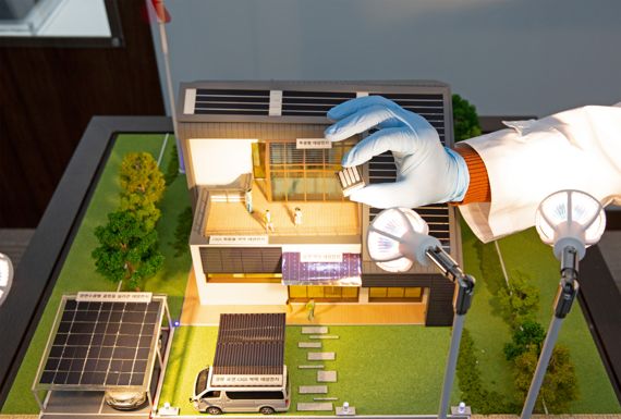 에너지기술연구원 태양광연구단 홍성준 박사가 새로 개발한 페로브스카이트 태양전지를 모형 주택의 조명 아래서 보여주고 있다. 에너지기술연구원 제공