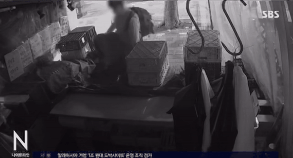 치마를 입은 40대 남성이 정육점에서 물건을 훔치고 있다./사진=SBS뉴스 캡처