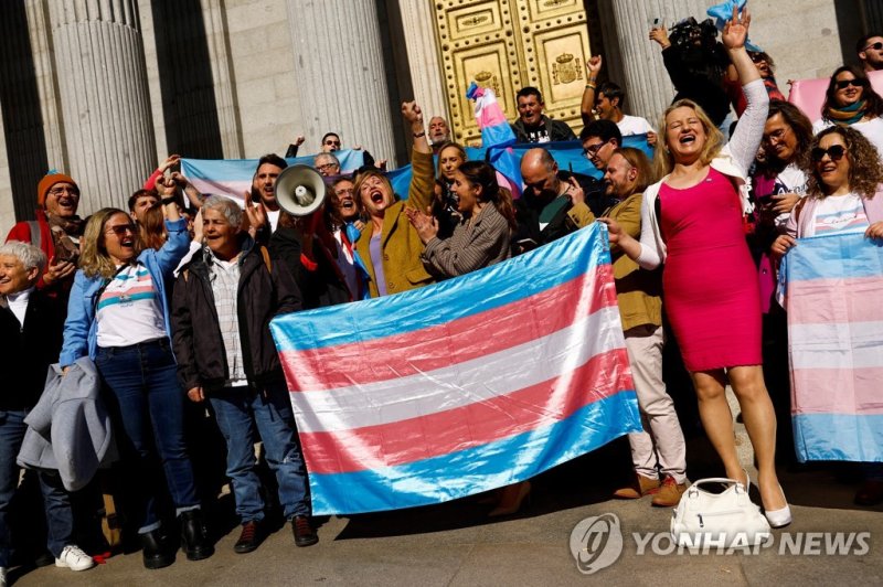 Spain's Minister for Equality Irene Montero (C) celebrates the final approval of a law that will make it easier for people to self-identify as transgender, with LGBT activists outside Spain's Parliament in Madrid, Spain, February 16, 2023. REUTERS/Susana Vera