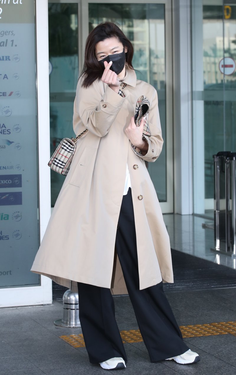 배우 전지현이 19일 패션쇼 참석차 인천공항에 도착해 영국 런던으로 출국하기 전 하트를 그리고 있다. ⓒ News1 권현진 기자