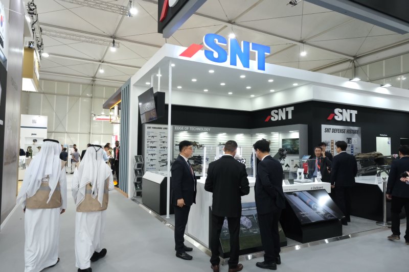 20~24일 아랍에미리트 아부다비에서 열리는 'UAE IDEX 2023' 전시회에 구성된 SNT 부스에서 회사 관계자가 자사 제품을 설명하고 있다. SNT그룹 제공