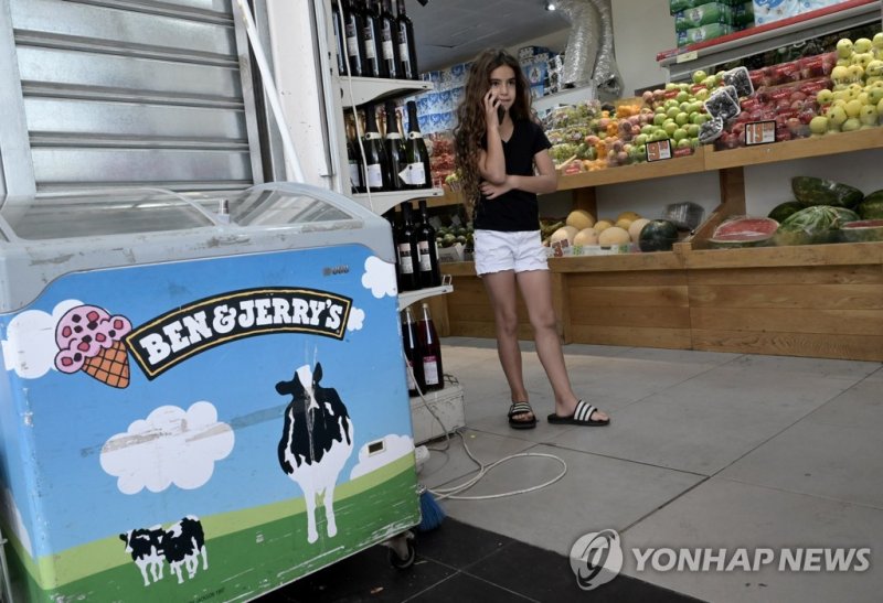 An Israeli girl talk on a cellphone beside a Ben & Jerry's ice cream freezer at a supermarket in the Jewish settlement Har Home, south of Jerusalem, on Friday, July 1, 2022. The Vermont based ice cream company, Ben & Jerry's said their boycott of Israel is still intact even though a local company wi