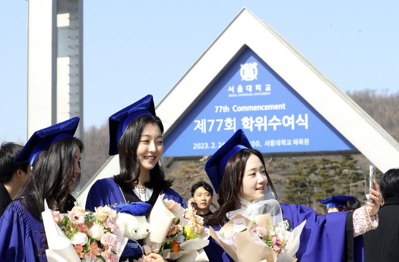 [서울=뉴시스] 최진석 기자 = 서울대학교 졸업생들이 24일 서울 관악구 서울대학교 정문 앞에서 2023년 서울대학교 제77회 학위수여식을 앞두고 기념촬영을 하고 있다. 2023.02.24. myjs@newsis.com