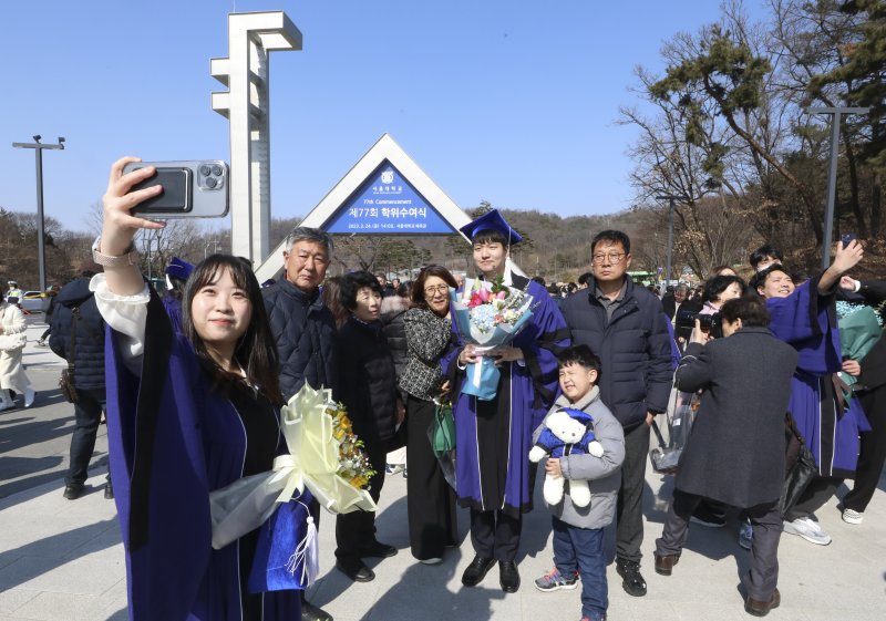 [서울=뉴시스] 최진석 기자 = 서울대학교 졸업생들이 24일 서울 관악구 서울대학교 정문 앞에서 2023년 서울대학교 제77회 학위수여식을 앞두고 가족과 기념촬영을 하고 있다. 2023.02.24. myjs@newsis.com