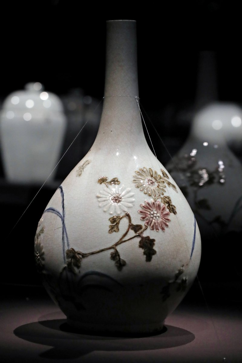 [서울=뉴시스] 박진희 기자 = 조선 초기 순백색의 단정함과 절제된 청화 장식의 백자에 이어 채색 백자 등장은 조선 후기에 형성된 새로운 전통이다. '백자 청화철채동채 초충문 병(白磁 靑畵鐵彩銅彩 草蟲文 甁)'는 가느다란 목에 비해 풍만한 몸채, 그 위에 곤충, 국화 문양을 도드라지게 문양을 만들었다. 여기에 난은 청화 안료를 덧입히고, 국화 잎과 줄기, 곤충은 철화 안료로 채색했다. 국화꽃은 철 안료, 동 안료로 잎마다 정성껏 칠한 것도 있지만 순백인 채로 둔 것도 있어 색색깔로 피어난 국화를 재치있게 표현했다. 청화, 철화, 동