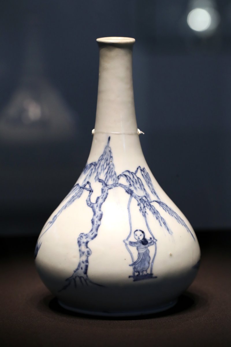 [서울=뉴시스] 박진희 기자 = 백자 장식에 인물이 등장하는 경우는 드물다. '백자청화 인물문 병(白磁靑畵 人物文 甁)'의 구성은 독특하다. 커다란 나무가지에 그네를 걸고 그 위에 양손을 벌려 줄을 붙든 채 치마자락 휘날리며 타고 있는 소녀의 모습을 중아에 배치했다. 벌어진 줄, 나부기는 치마자락 등 리얼리티가 살아 있다. 이외도 나무가지를 들고 있는 여인, 담배 피는 여인, 묶여있는 나귀 등 당시 생활상을 들여볼 수 있는 흥미로운 작품이다. 2023.02.26. pak7130@newsis.com