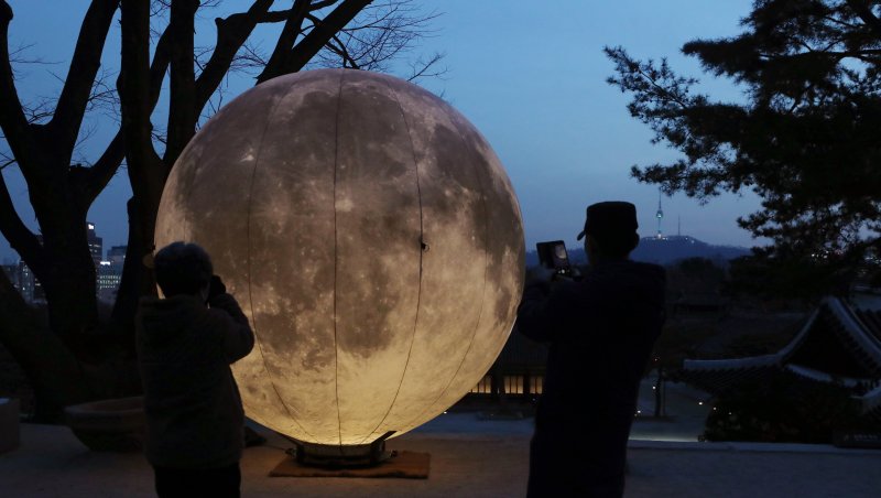 [서울=뉴시스]김병문 기자 = 정월 대보름을 이틀 앞둔 24일 오후 서울 종로구 창경궁 풍기대 주변에 대형 모형 보름달을 띄우는 '궁궐에 내려온 보름달' 행사를 찾은 시민이 휴대전화로 찍고 있다. 2021.02.24. dadazon@newsis.com