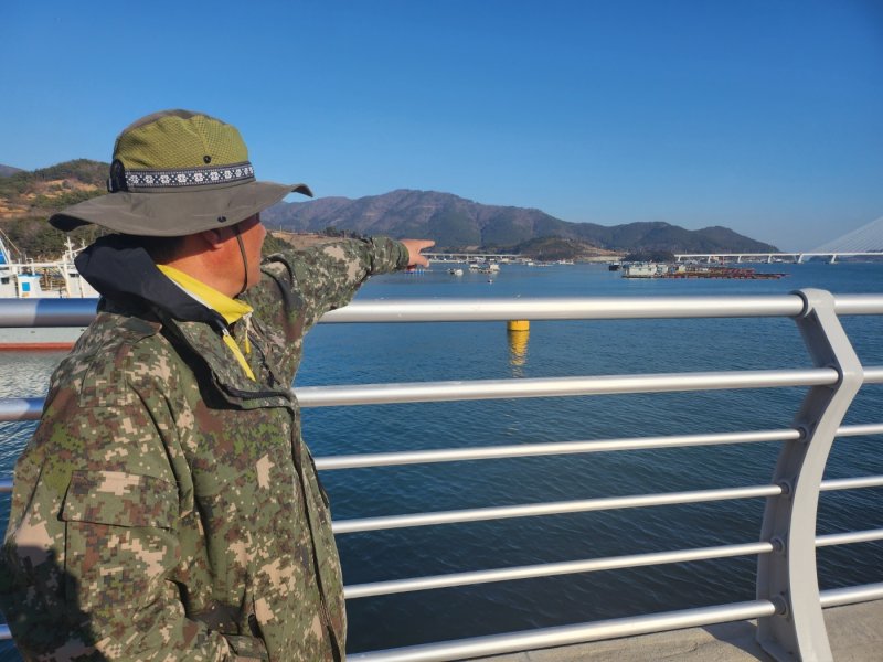 우성주 여수시수산업경영인연합회장이 27일 여수 돌산 군내선착장에서 피해 가두리 양식장을 가리키고 있다.2023.2.28/뉴스1