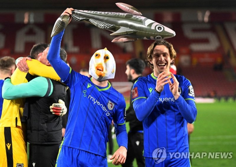 승리 뒤 물고기 탈 쓰고 풍선 들고 자축하는 그림즈비 타운의 선수 Soccer Football - FA Cup - Fifth Round - Southampton v Grimsby Town - St Mary's Stadium, Southampton, Britain - March 1, 2023 Grimsby Town's Anthony Driscoll-Glennon wears a fish mask and displays an inflatable fish as he celebrates with Danilo Orsi-Dadomo after 
