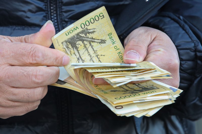 서울 시내 은행 ATM에서 시민이 현금 5만원권을 세고 있다. 뉴시스