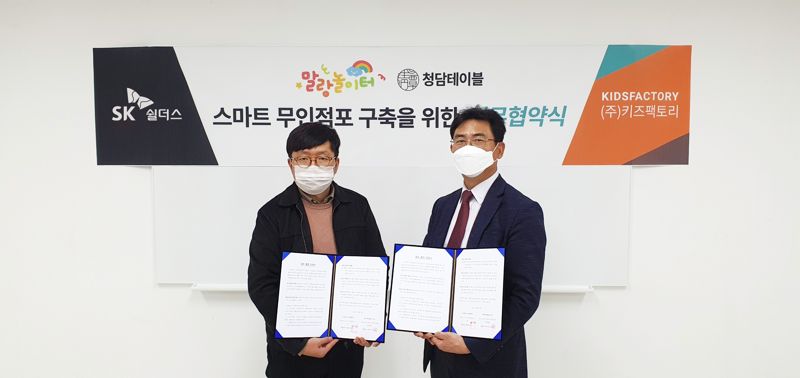 SK쉴더스가 키즈팩토리와 함께 ‘캡스 무인안심존’ 솔루션 적용 무인매장 확대에 나선다. SK쉴더스 서울서전략영업팀 손성호 팀장(오른쪽)과 키즈팩토리 채원석 대표(왼쪽)가 사진 촬영을 하고 있다. SK쉴더스 제공.