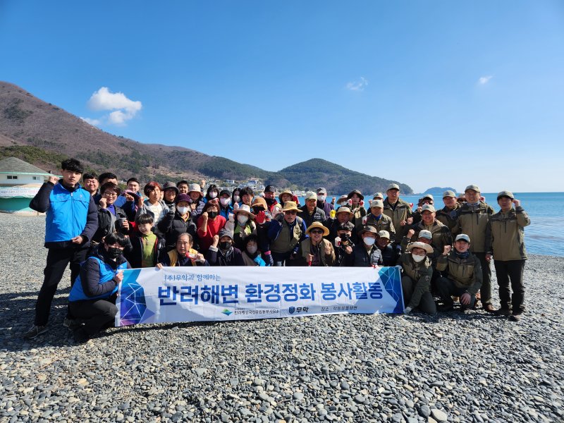 무학 좋은데이 봉사단과 한려해상국립공원 거제분소, 학동마을 주민들이 지난달 28일 거제시 학동흑진주몽돌해수욕장에서 환경정화활동을 진행하고 기념촬영을 하고 있다. 무학 제공