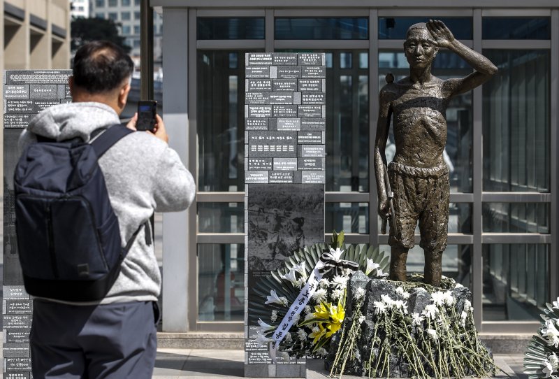 [서울=뉴시스] 정병혁 기자 = 6일 오후 서울 용산구 용산역광장에 세워진 강제징용노동자상 앞에서 한 시민이 사진을 찍고 있다. 정부는 이날 일제 강제징용 해법과 관련해 행정안전부 산하 '일제강제동원피해자지원재단'이 강제지용 피해자인 원고에 판결금 및 지연 이자를 지급할 것이라고 밝혔다. 재단의 재원은 민간의 자발적 기여 등을 통해 마련하기로 했다. 2023.03.06. jhope@newsis.com