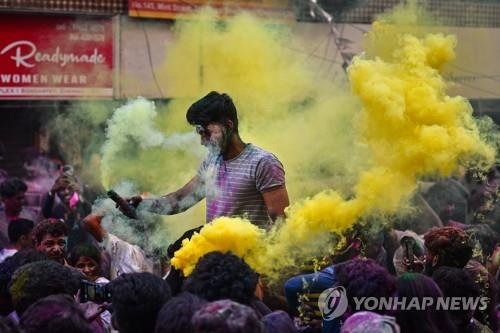 8일 인도 첸나이에서 색연기 속에서 홀리를 즐기는 이들. [EPA 연합뉴스 자료사진. 재판매 및 DB 금지]