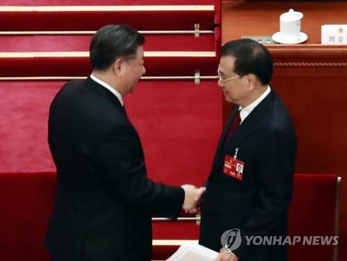 중국 최고 입법기관인 전국인민대표대회(전인대) 연례회의가 2022년 5월 개막한 베이징 인민대회당에서 시진핑 국가주석이 리커창 총리와 악수하고 있다.