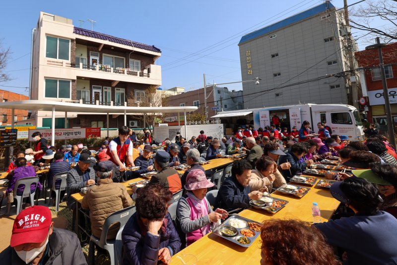 경남정보대가 지난 10일 부산 사상구 감전동 당산공원에서 어르신들에게 점심을 대접하고 있다. 경남정보대 제공